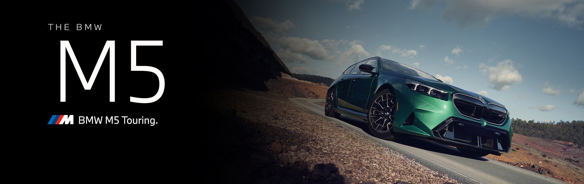 The new BMW M5 Touring in green driving down desert road | BMW of Allentown in Allentown PA